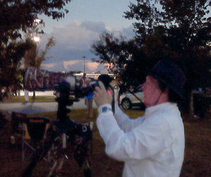 A not so good shot of me checking images during totality. Kinda dark and taken with a tablet camera.